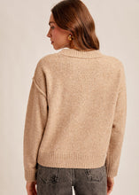Load image into Gallery viewer, Woman wearing a beige sweater and dark jeans against a plain background
