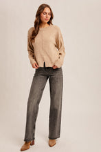 Load image into Gallery viewer, Woman wearing a beige sweater and gray jeans on a plain background
