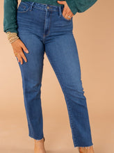 Load image into Gallery viewer, In a classic straight-leg silhouette, these high-rise jeans are perfect for showcasing your best assets. Dress them up or down for any weekday or weekend. These jeans have no distressing, a great wash, and scissor cut bottom hems.   Chelsey is wearing a size 25 in the light denim Justice is wearing a size 29 n the dark denim Runs true to size  93% Cotton 5% Polyester 2% Spandex Wash Instructions   Hand wash cold separately. Do not bleach. Hang to dry.
