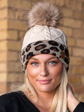 Load image into Gallery viewer, Ivory with leopard cuff cable knit fleece lined hat with pom accent
